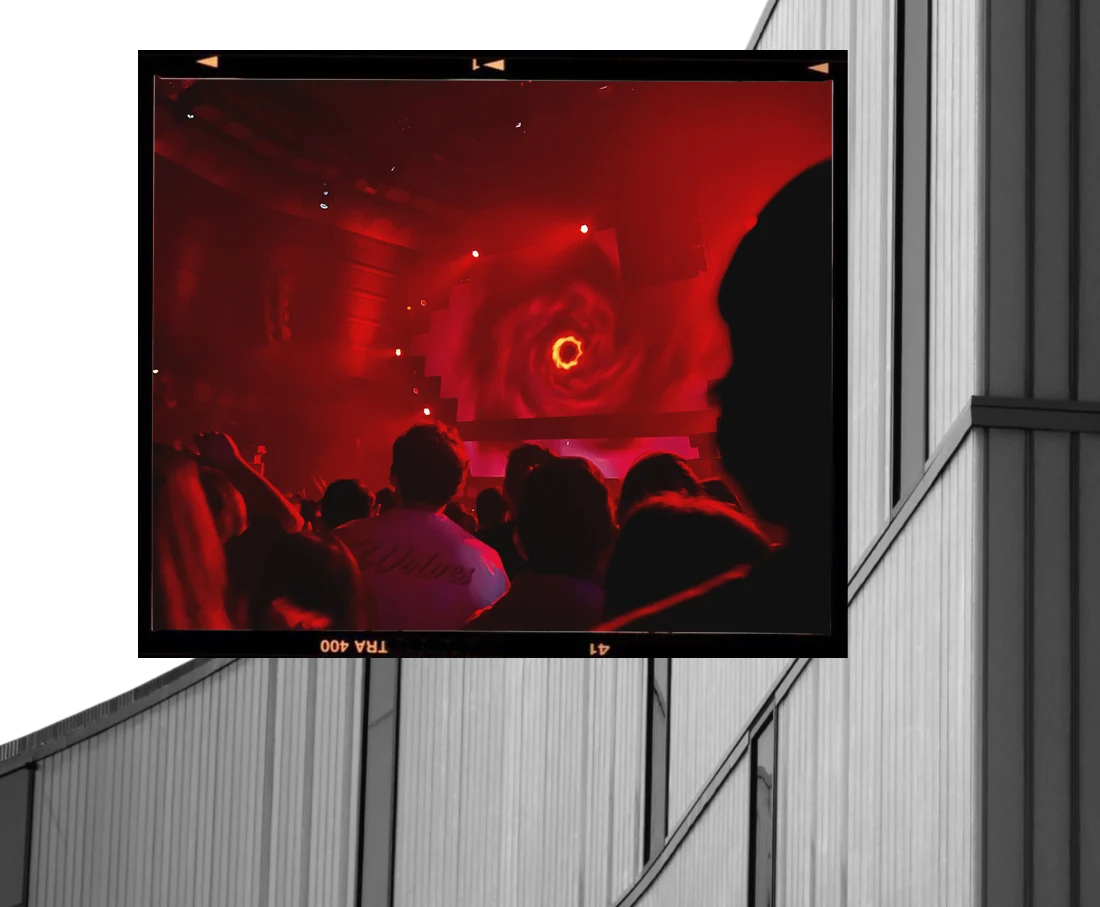 A concert photo in a film frame over a curved building
